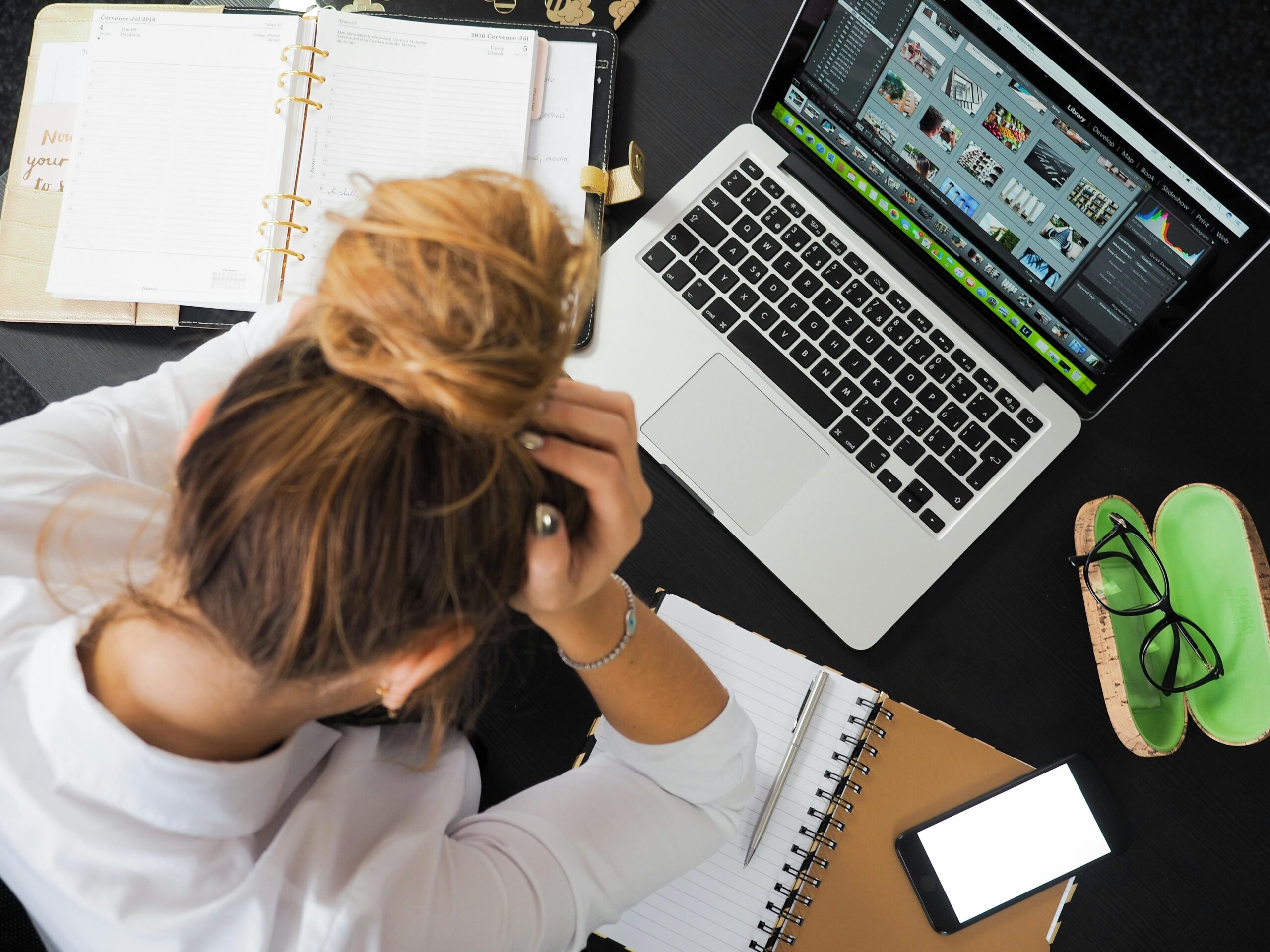A woman overwhelmed by work at her laptop
