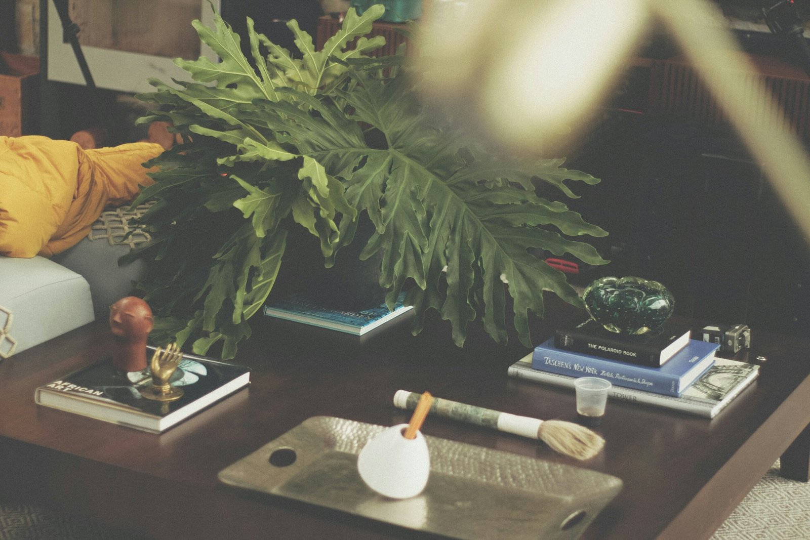 A minimalist desk setup with a plant, candle, and books