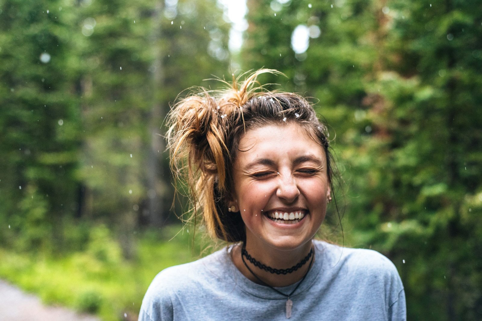 A young woman smiling while meditating outdoors