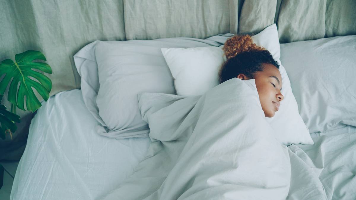 A woman smiling happily after waking up feeling refreshed