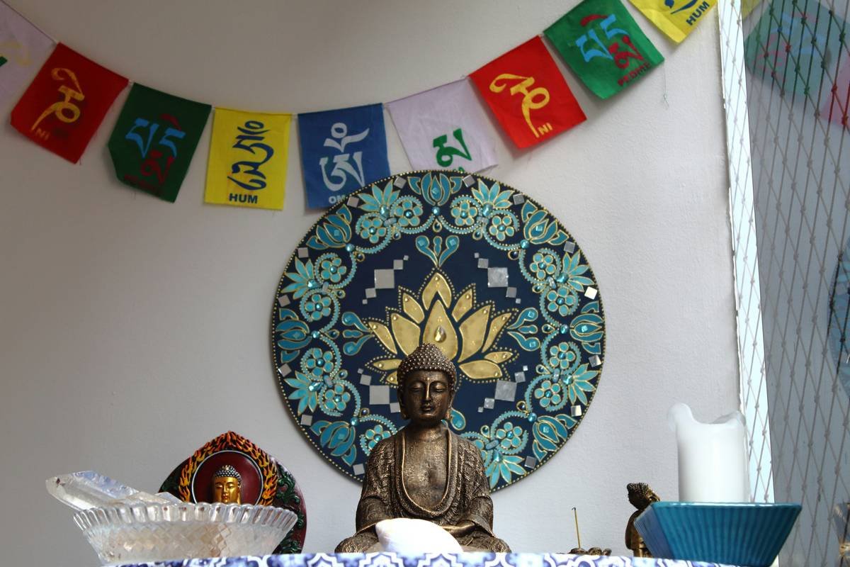 A serene zen altar featuring candles, crystals, and a Buddha statue