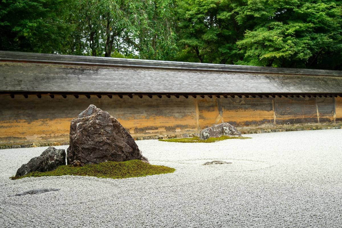 A small zen rock garden with smooth stones arranged neatly in white sand